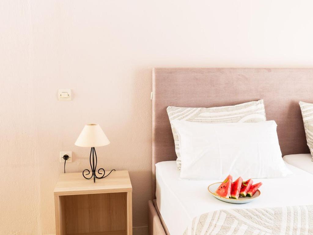 a bedroom with a bed with a bowl of watermelon at Houmis Apts & Studios in Agios Georgios Pagon