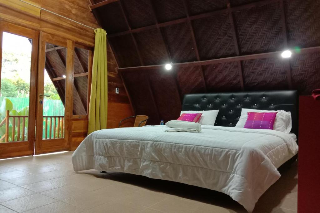 een slaapkamer met een groot bed in een kamer bij Villa Alam Flores Komodo Labuan Bajo Mitra RedDoorz in Labuan Bajo