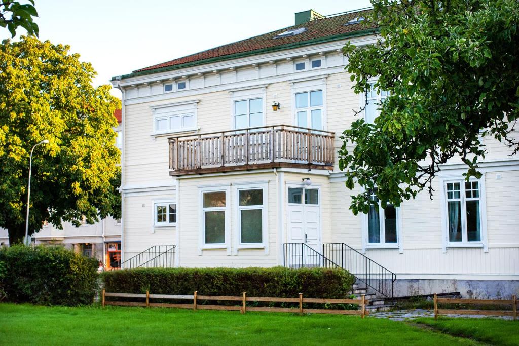 a large white house with a balcony on it at Vänersborgs Vandrarhem in Vänersborg