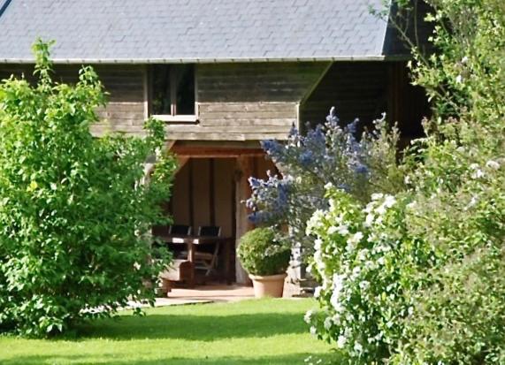 una casa con un patio con árboles y plantas en Bergerie de la Moutonnière, en Le Pin