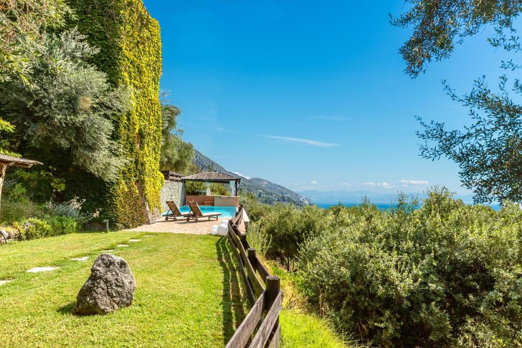 a house with a garden with a swimming pool at Villa Manavra in Ipsos