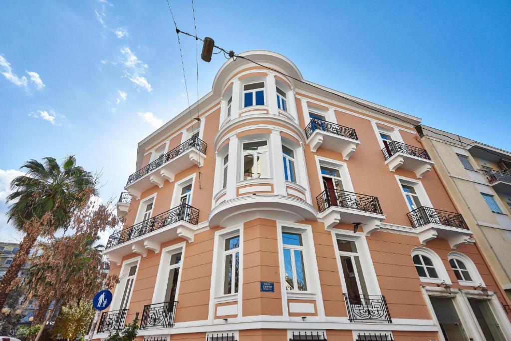 un grand bâtiment orange avec des finitions blanches dans l'établissement Exis Hotel, à Athènes