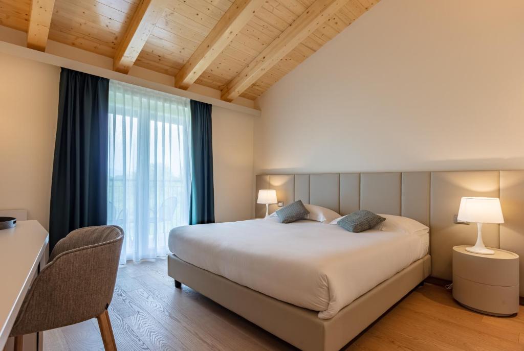 a bedroom with a large bed and a large window at Leonardo Hotel Lago di Garda - Wellness and Spa in Lazise