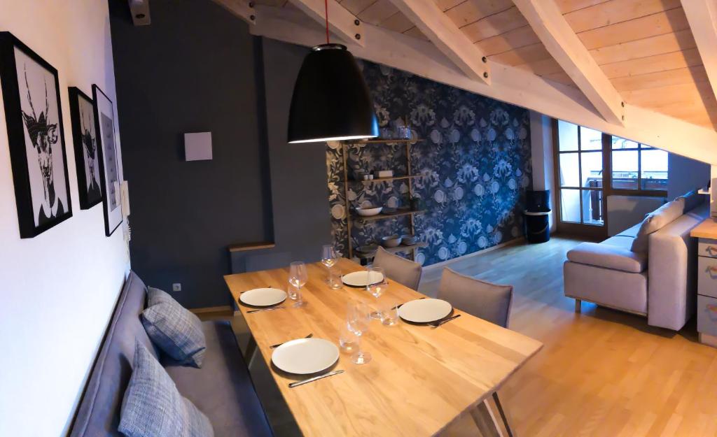 comedor con mesa de madera y sofá en Ferienwohnung Alpzeit en Blaichach