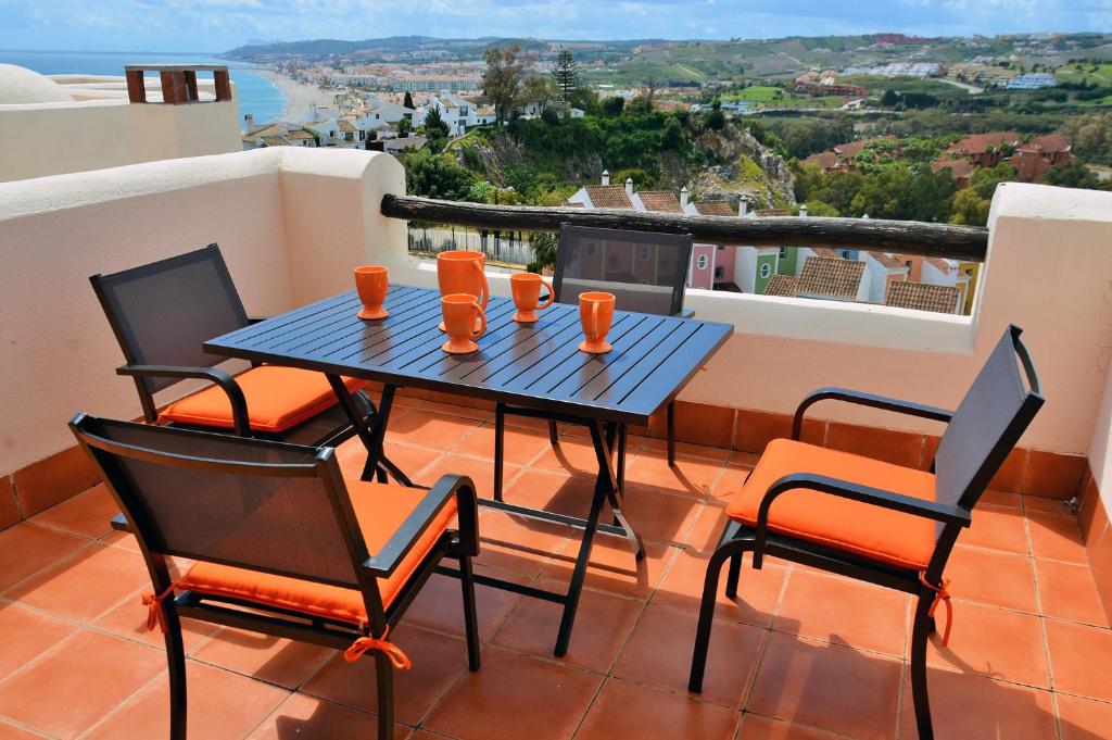 d'une table et de chaises sur un balcon avec vue. dans l'établissement Vista Bahía, à Casares