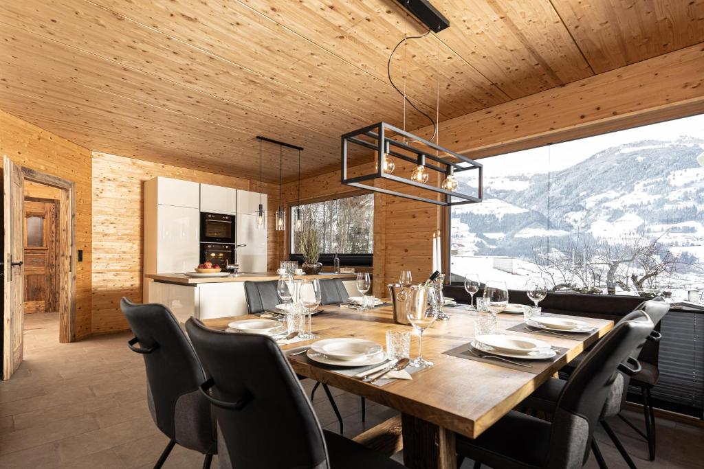 a kitchen and dining room with a wooden table and chairs at Naturlodge Tirol - Naturverbunden im Zillertal in Fügen