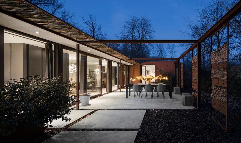 een patio met een tafel en stoelen buiten een gebouw bij Stalen Boshuis in Oosterhout