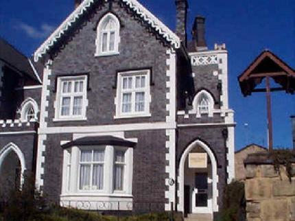 um grande edifício preto e branco com uma torre de relógio em Park House Guest House em Warwick