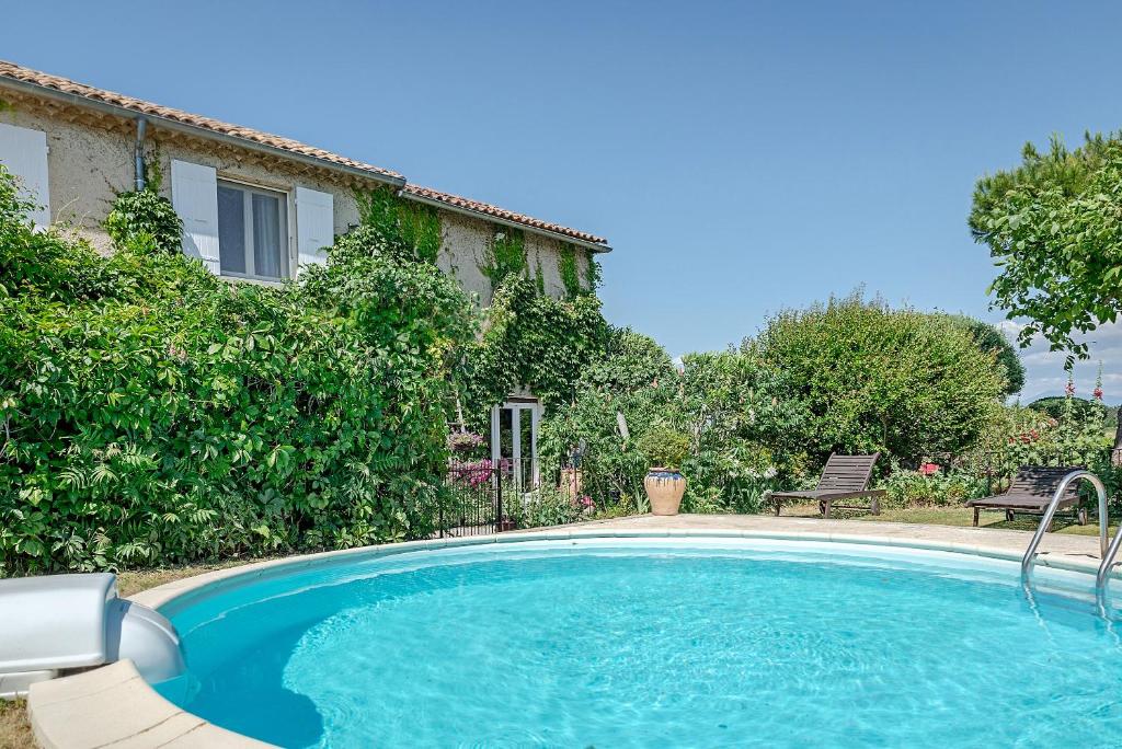a swimming pool in front of a house at Chambres d'Hôtes et Gîtes Le Mas Mellou in Orange