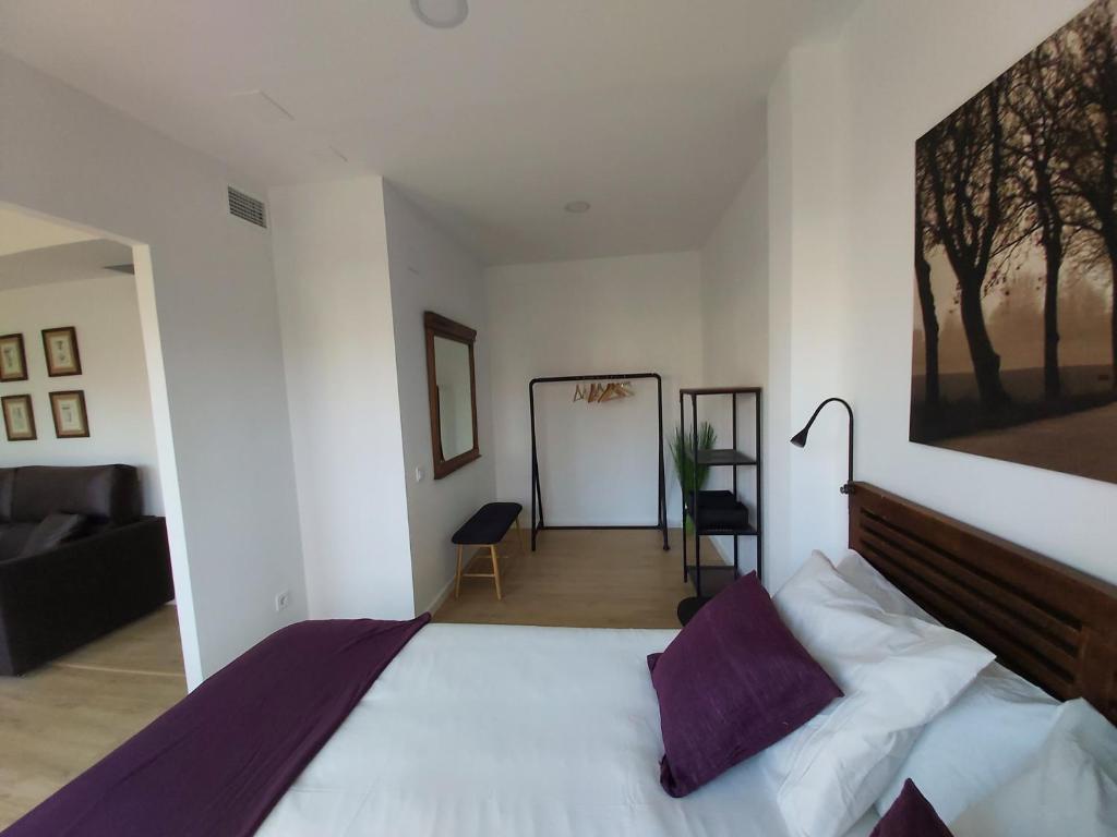 A bed or beds in a room at Acero y Piedra Apartamentos con jardín privado