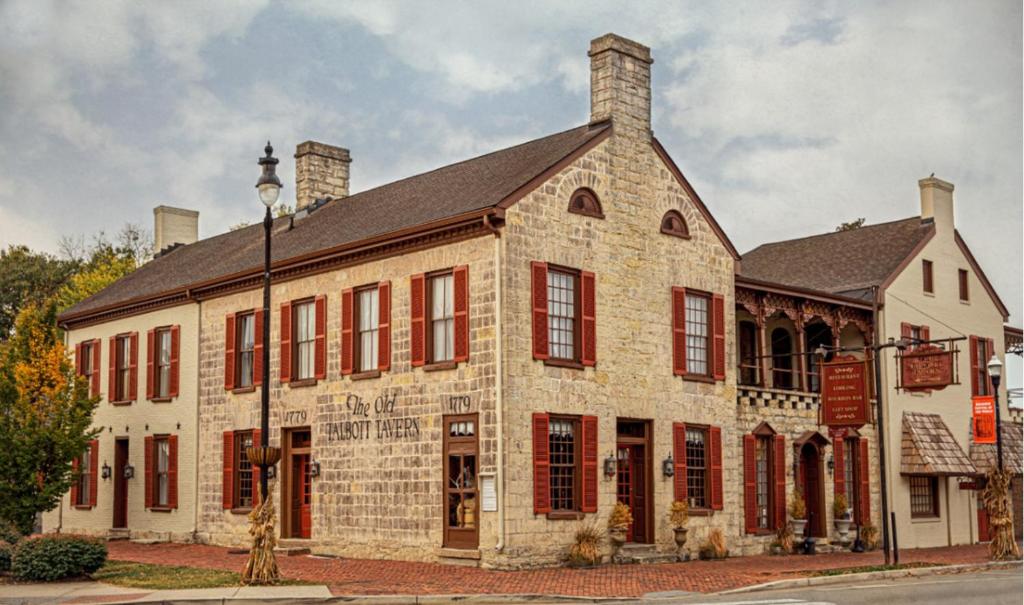 a large brick building with red windows and a street light at Talbott Tavern and Inn in Bardstown