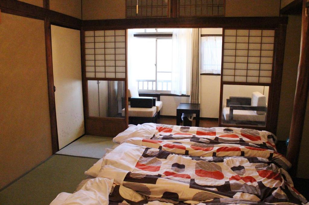 a bedroom with a bed with a quilt on it at Guesthouse Higashiyama Jao in Kyoto