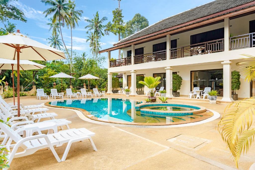 um resort com piscina e cadeiras e um edifício em Royal Cottage Residence em Lamai
