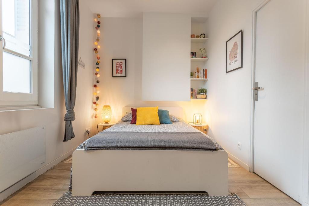 a bedroom with a large white bed in a room at Le Cocon Lumière in Lyon