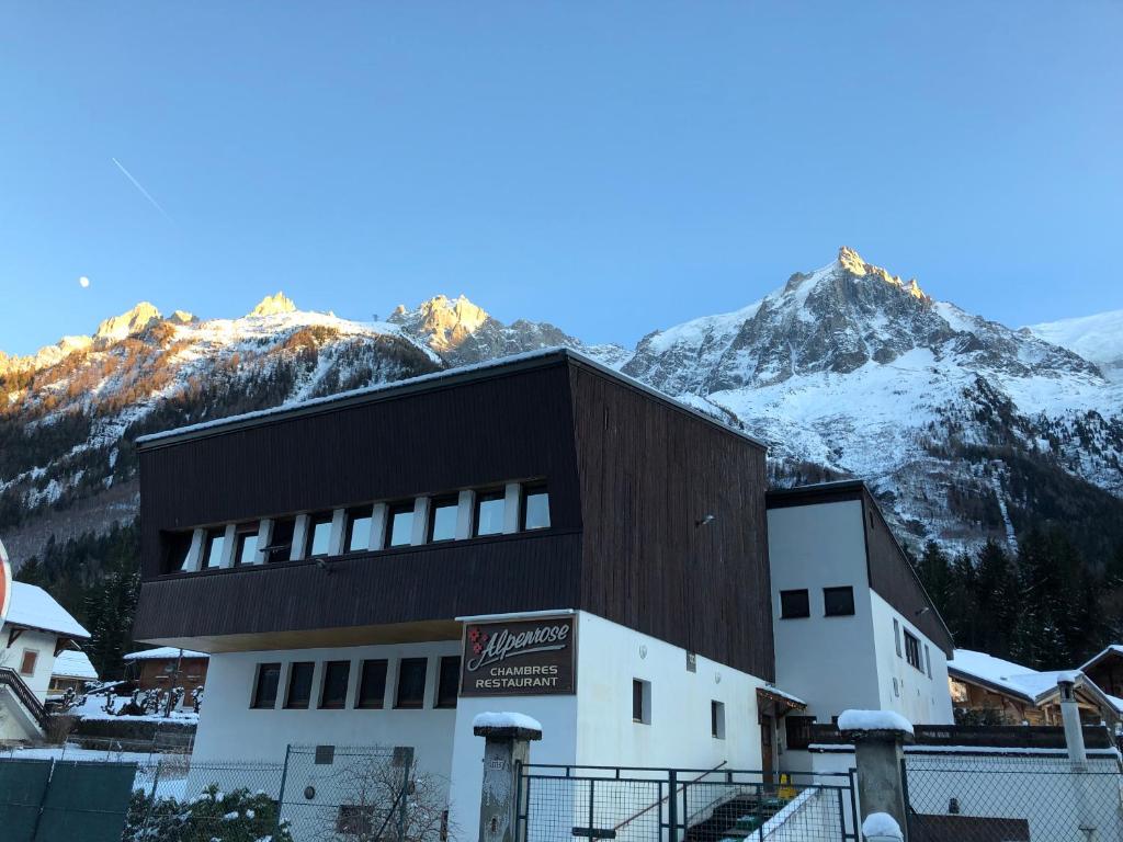 un edificio con una montaña cubierta de nieve en el fondo en Alpenrose Chamonix, en Chamonix-Mont-Blanc