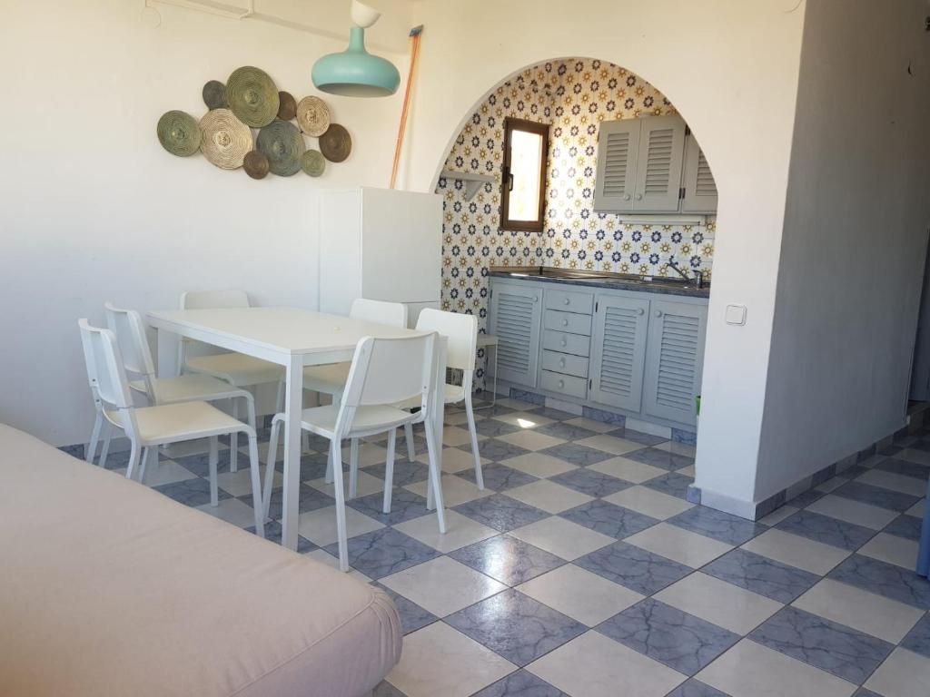 cocina y comedor con mesa y sillas en Formentera Es Pujols 2 camere vicinissimo alla spiaggia, en Es Pujols