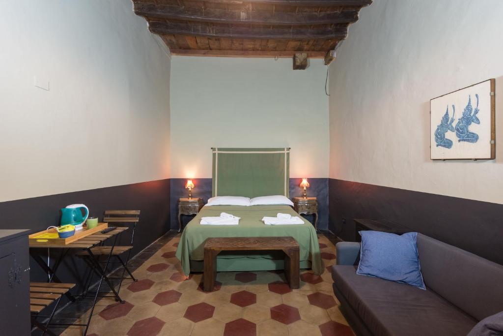 ein Schlafzimmer mit einem Bett und einem Sofa in einem Zimmer in der Unterkunft Le petit coeur de la ville in Turin