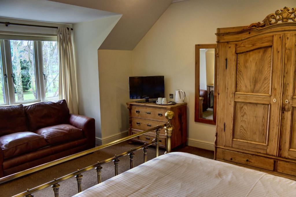 a living room with a couch and a tv at Sedlescombe Golf Hotel in Sedlescombe