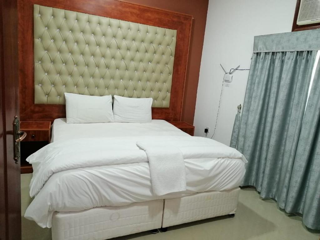 A bed or beds in a room at Discovery Furnished Apartments (Al-Amerat)