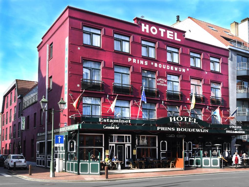 a red hotel on the corner of a street at Hotel Prins Boudewijn in Knokke-Heist