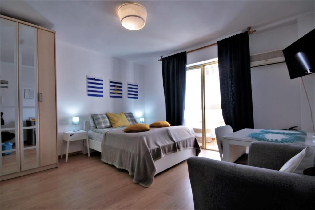 a bedroom with a bed and a room with a window at Estudio Marina de Santa Pola in Santa Pola