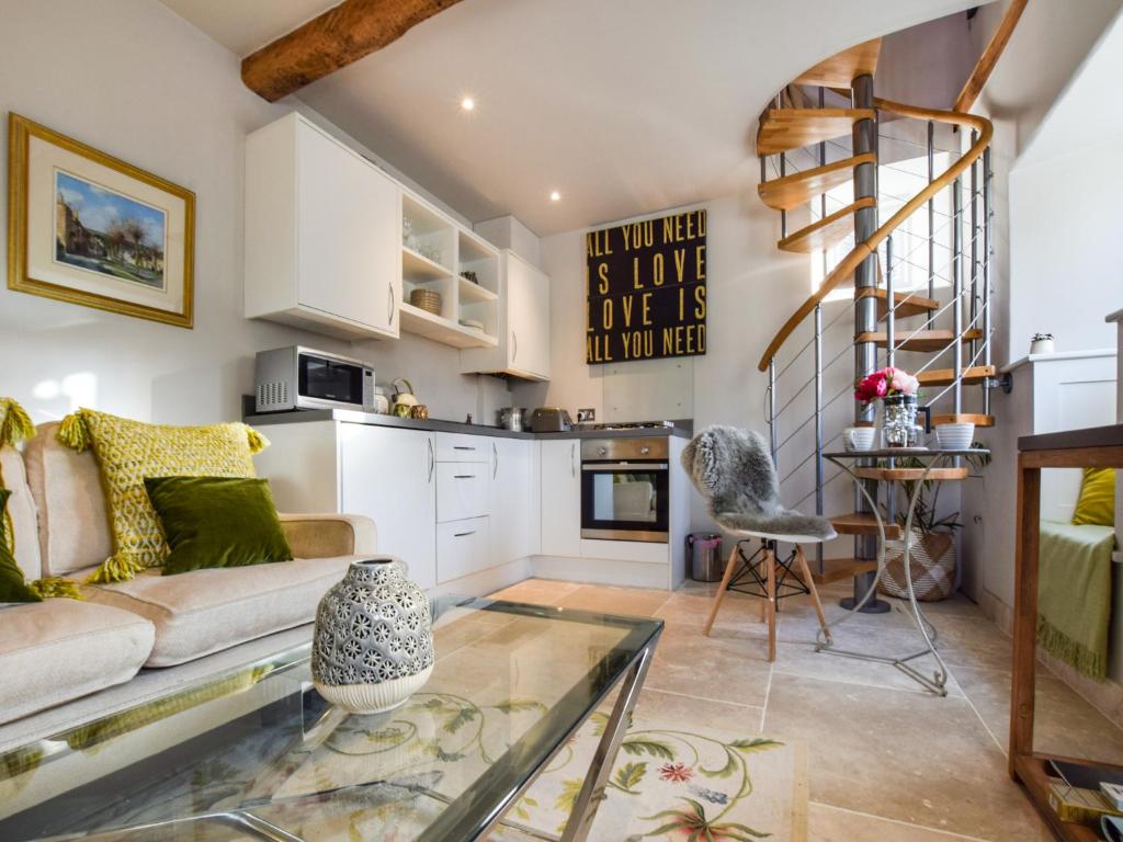 a living room with a couch and a glass table at Bothy in Bibury