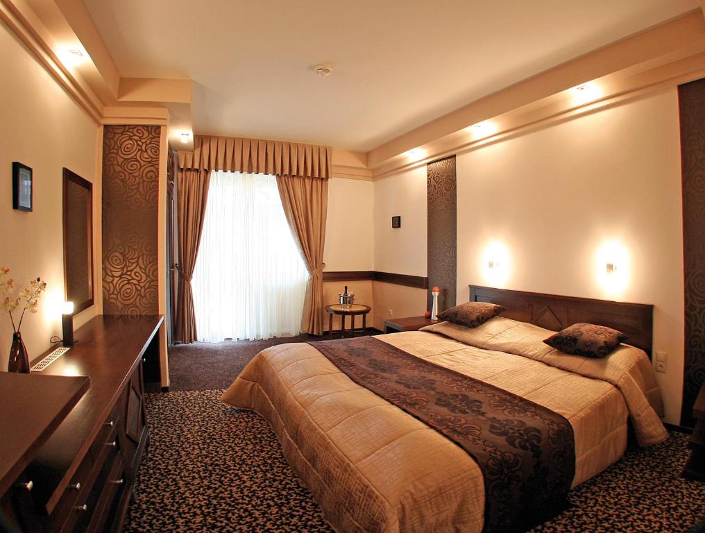 Un pat sau paturi într-o cameră la Hunguest Hotel Apollo