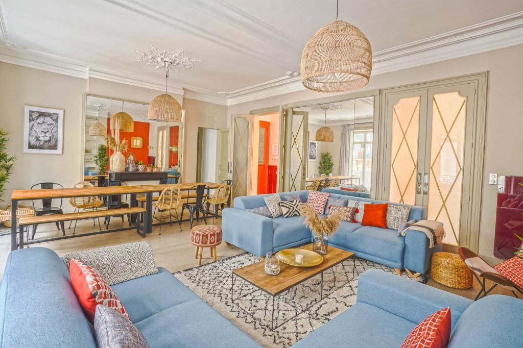 uma sala de estar com sofás azuis e uma sala de jantar em NOCNOC - Le Terracotta em Montpellier