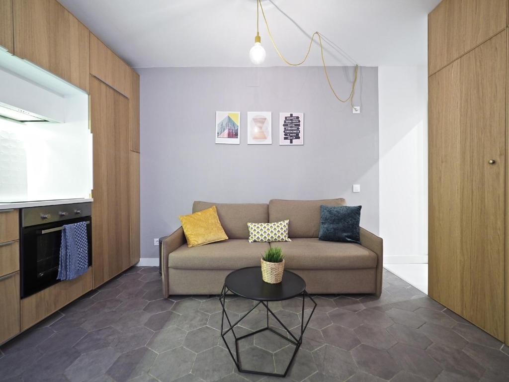 ein Wohnzimmer mit einem Sofa und einem Tisch in der Unterkunft Torrassa Cozy Apartment by Olala Homes in Hospitalet de Llobregat