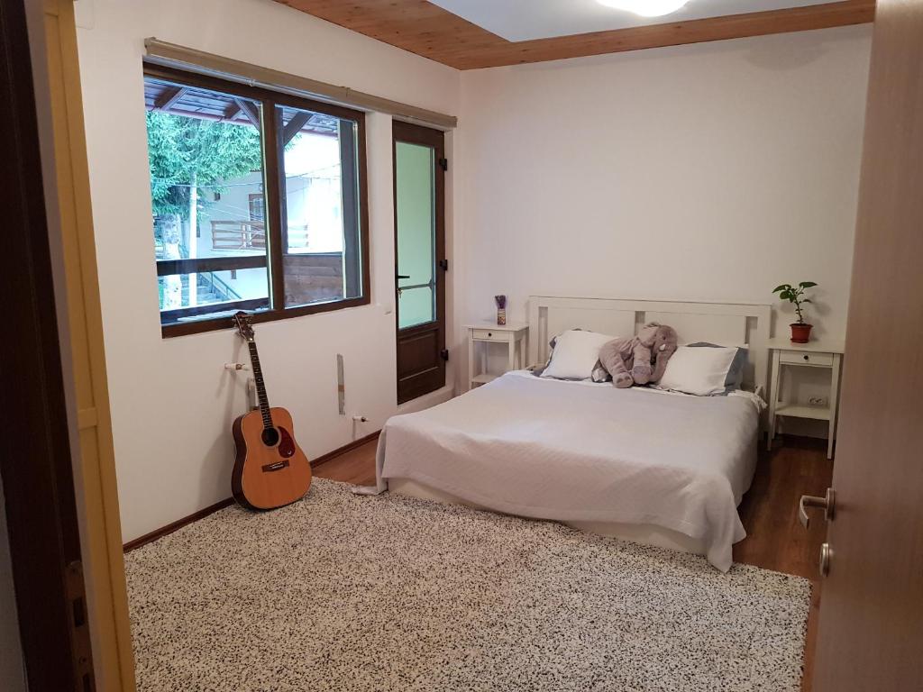 Schlafzimmer mit einem Bett mit Gitarre in der Unterkunft Forest Apartments by Olala Homes in Sinaia