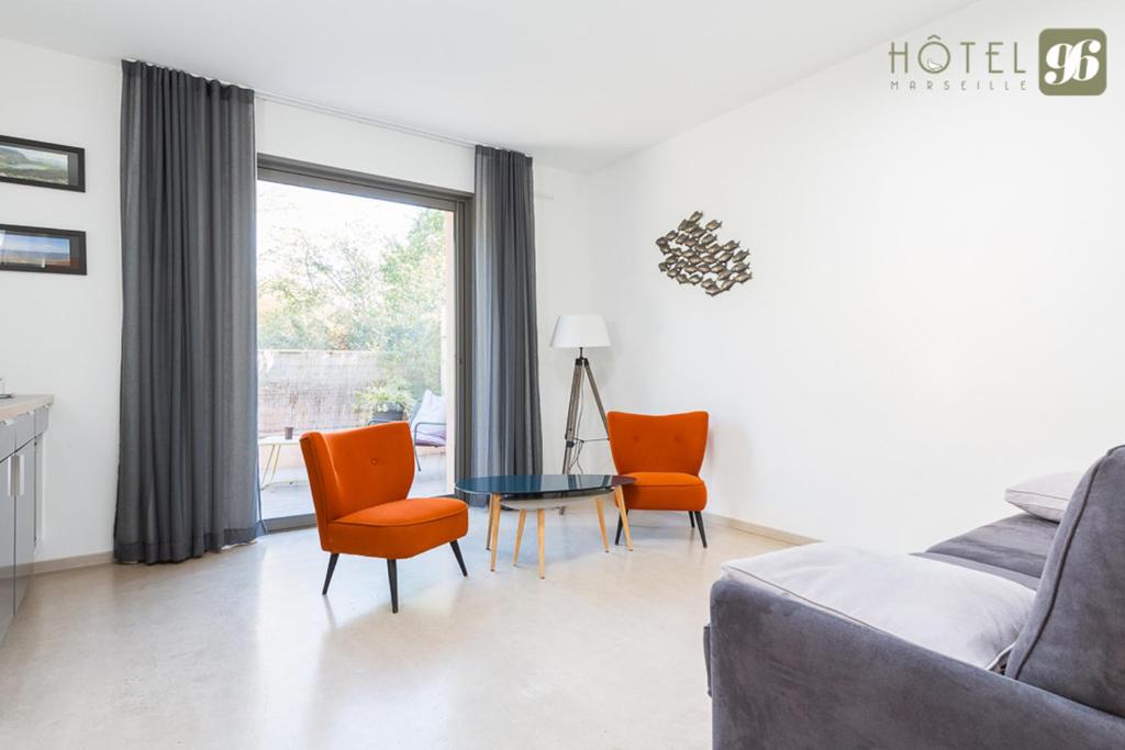 a living room with a couch and chairs and a table at Hôtel 96 in Marseille