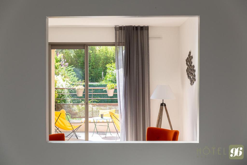 a living room with a sliding glass door to a patio at Hôtel 96 in Marseille