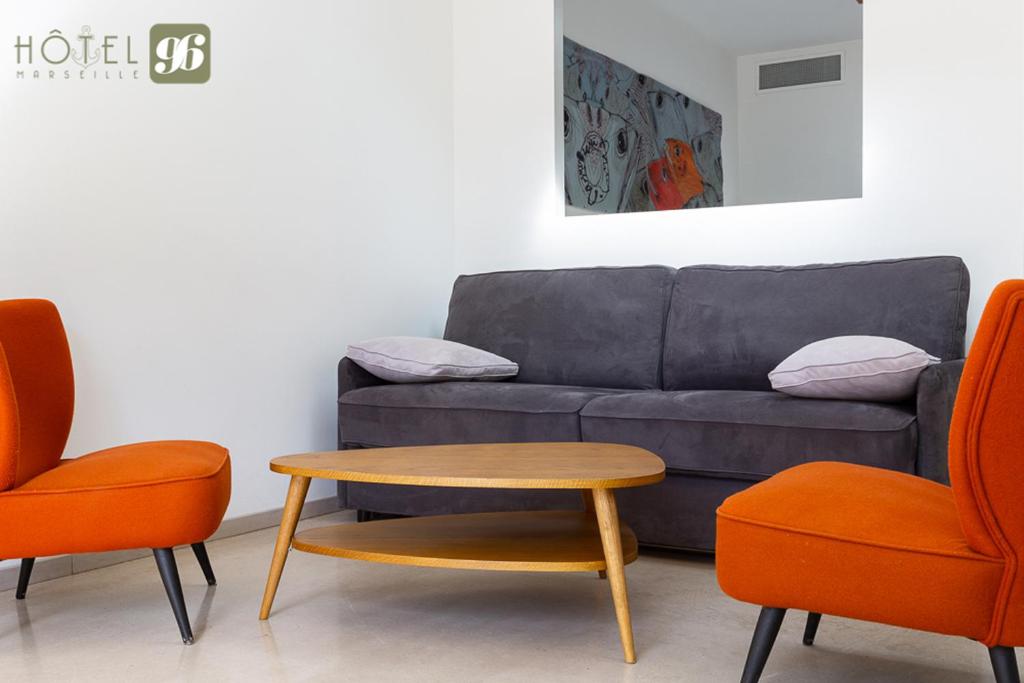 a living room with a couch and two chairs at Hôtel 96 in Marseille