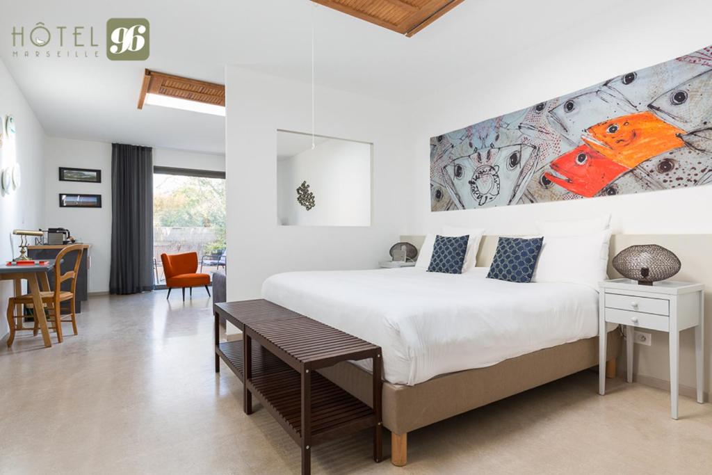 a bedroom with a large bed and a dining room at Hôtel 96 in Marseille