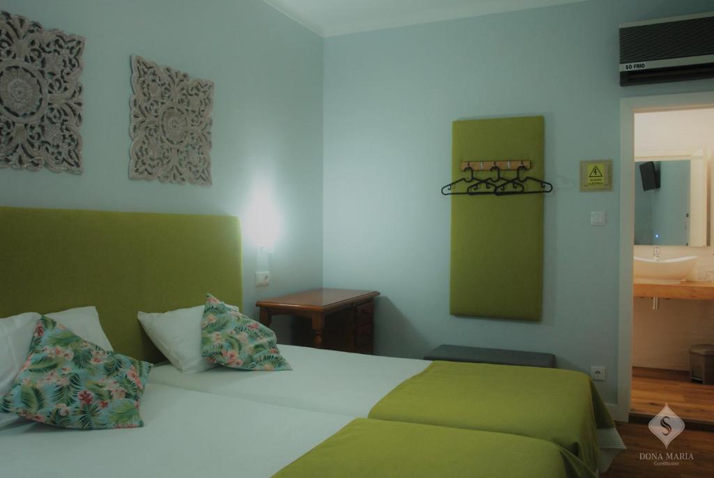 um quarto com uma cama e uma casa de banho com um lavatório em Dona Maria em Portalegre