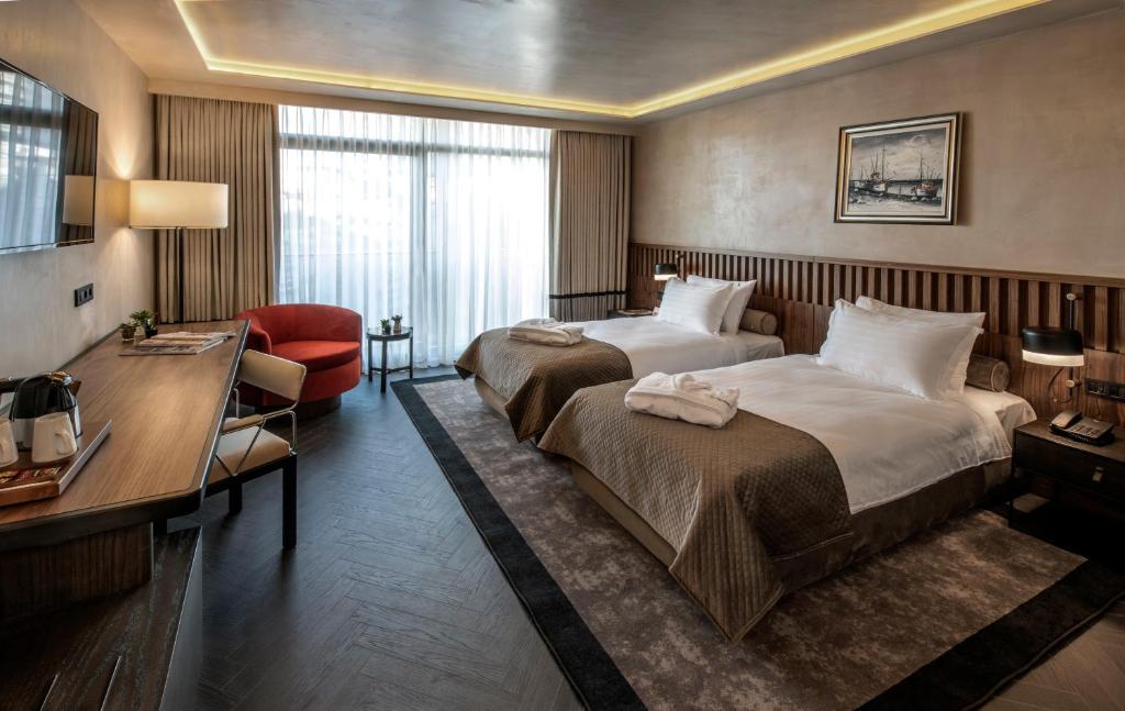 Pokój hotelowy z 2 łóżkami i biurkiem w obiekcie Hotel Bosfora Plus w Stambule