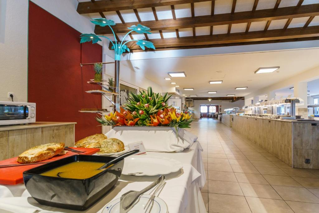 a cafeteria with a buffet line with food at Minura Cala Galdana & Apartamentos d'Aljandar in Cala Galdana