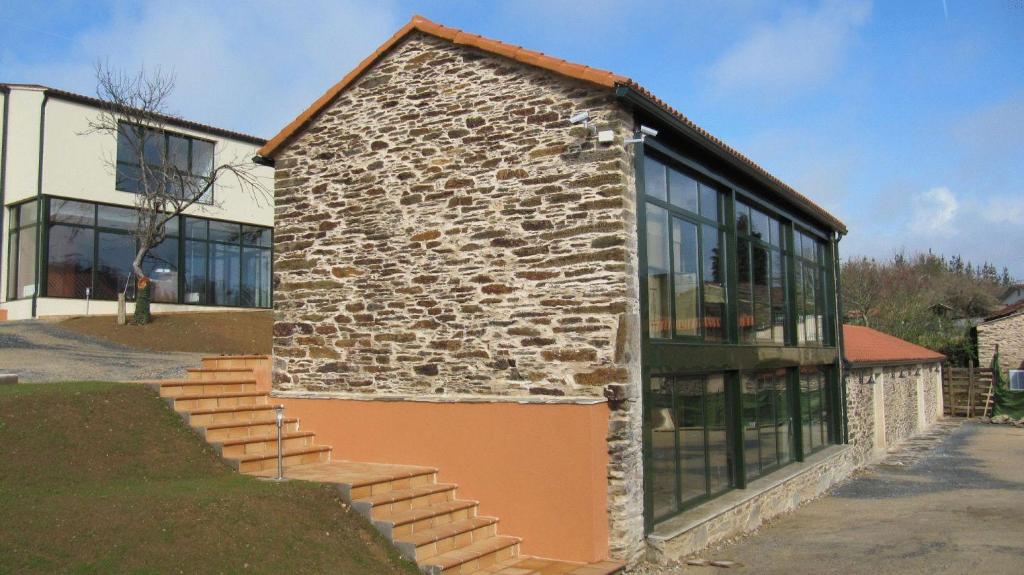 un edificio de piedra con un montón de ventanas en Hotel Amenal en Amenal