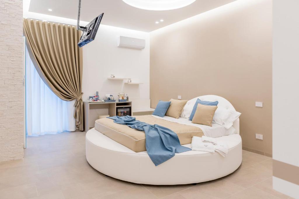 een woonkamer met een witte bank en een bed bij Romantic Suite in Monopoli