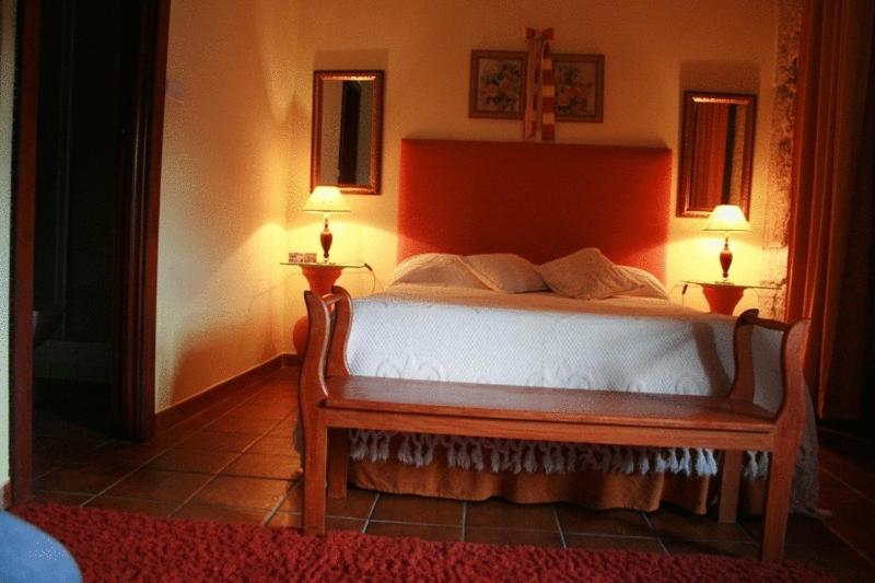 a bed in a room with two lamps on the wall at Residencial Panorama in Covilhã