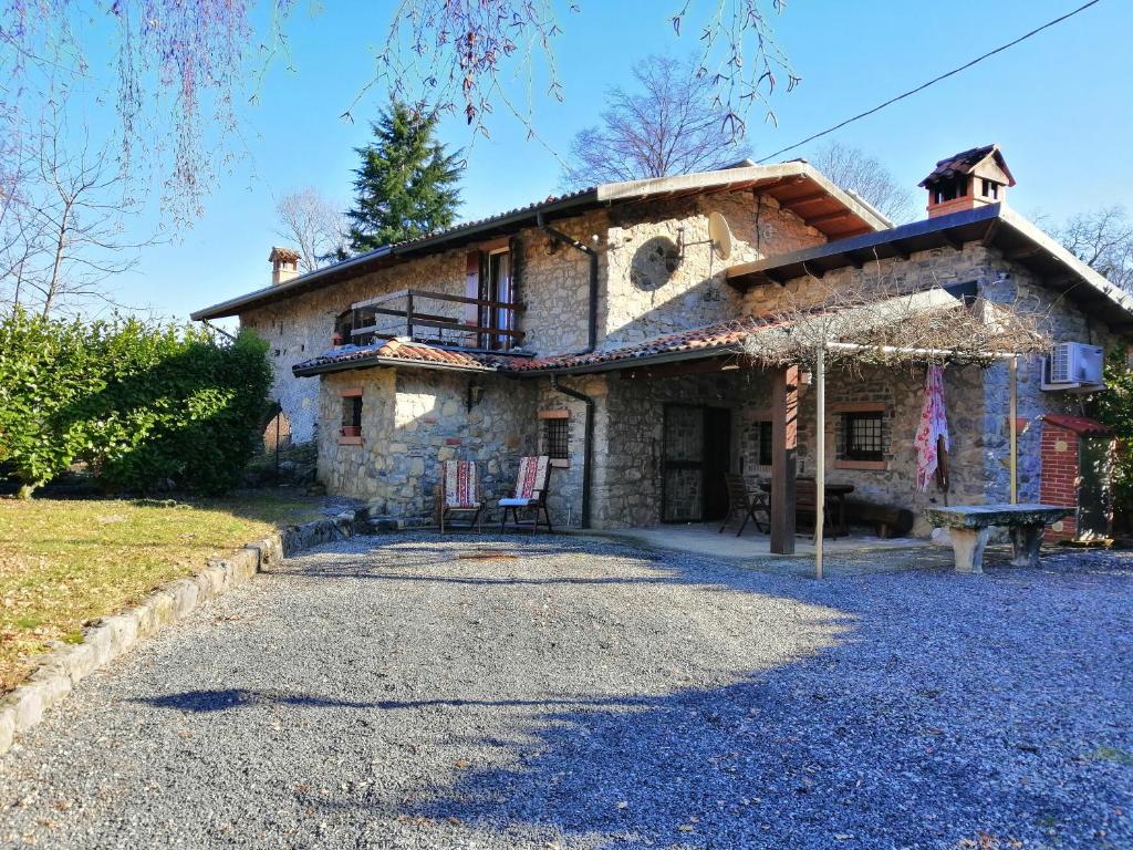 una gran casa de piedra con una entrada delante de ella en IseoLakeRental - Chalet di Elena, en Solto Collina