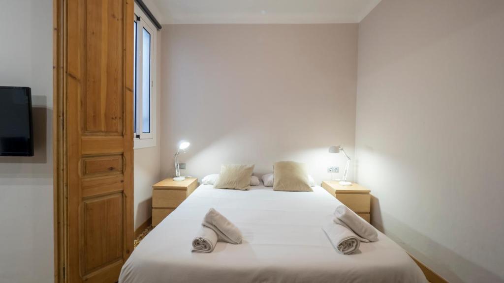 um quarto com 2 camas e 2 candeeiros e uma televisão em Acogedor apartamento de 2 dormitorios em Barcelona