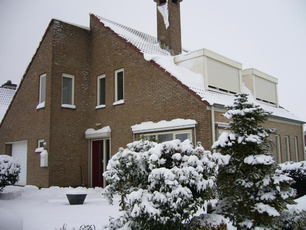 uma grande casa de tijolos com neve em B&B Korendijk em Zuid-Beijerland