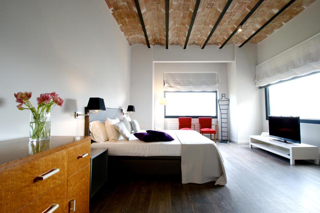 巴塞隆納的住宿－Decô Apartments Barcelona-Diagonal，一间卧室配有一张大床和电视