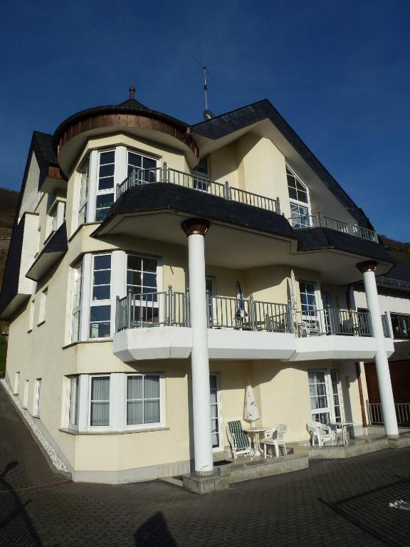 a large building with a balcony and a table and chairs at Ferienwohnung Sewenig in Müden