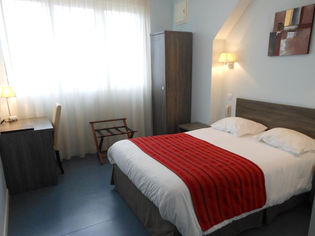 Cette chambre comprend un grand lit avec une couverture rouge. dans l'établissement Hotel du Parc, à Châteauneuf-sur-Loire