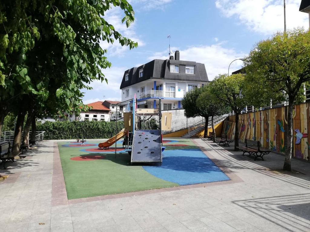 un parque infantil con un tobogán frente a un edificio en Txokomaitea, en Urnieta