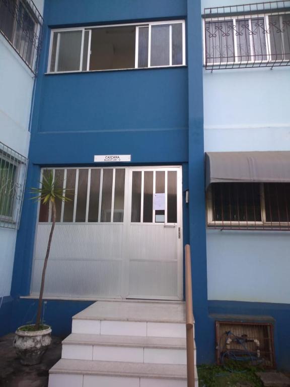 ein blaues Gebäude mit einer Tür und einer Palme in der Unterkunft Apartamento Praia Coqueiral de Itaparica - Vila Velha in Vila Velha