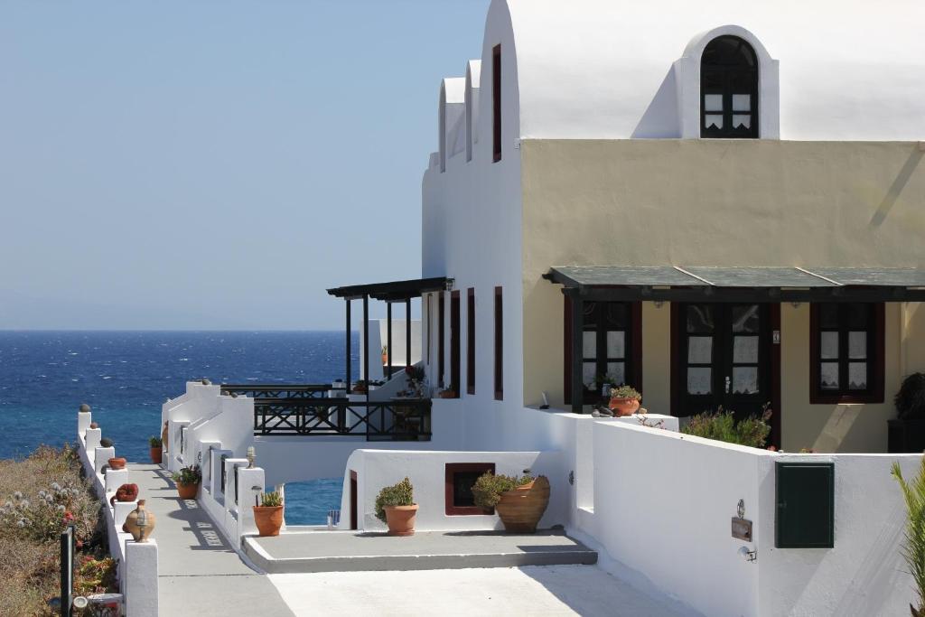 a white house with a balcony overlooking the ocean at Vrachia Studios & Apartments in Oia