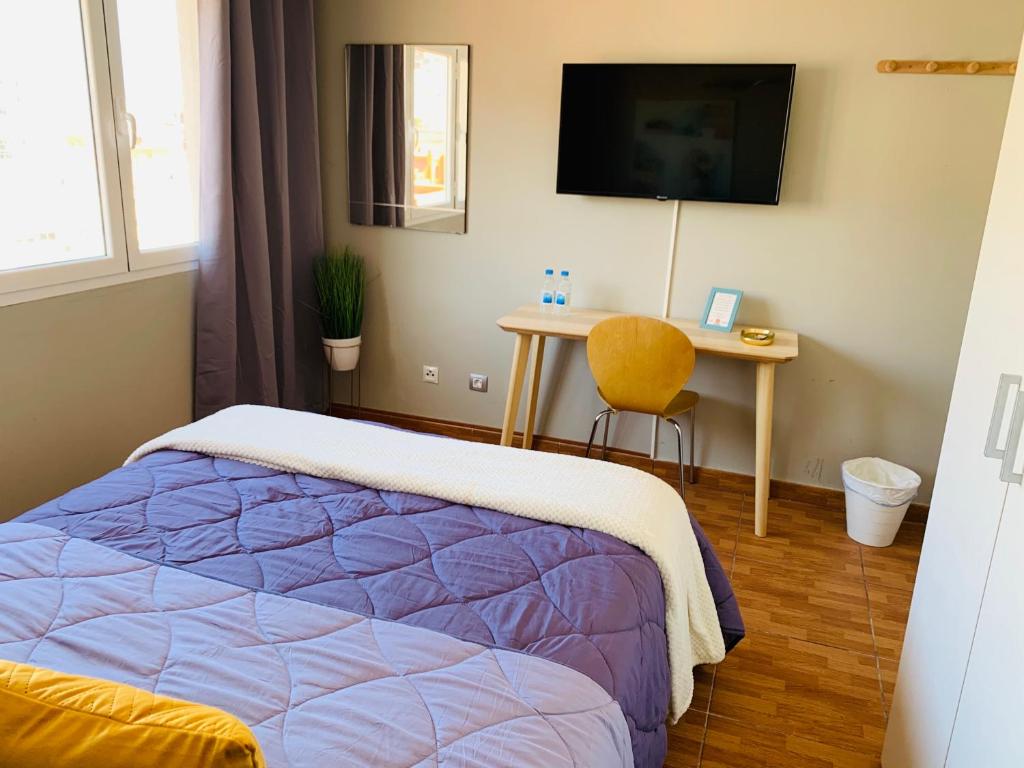 1 dormitorio con 1 cama y escritorio con TV en BYOR City Rooms en Las Palmas de Gran Canaria